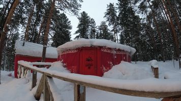 red snow-covered shelter with wooden railing in the foreground