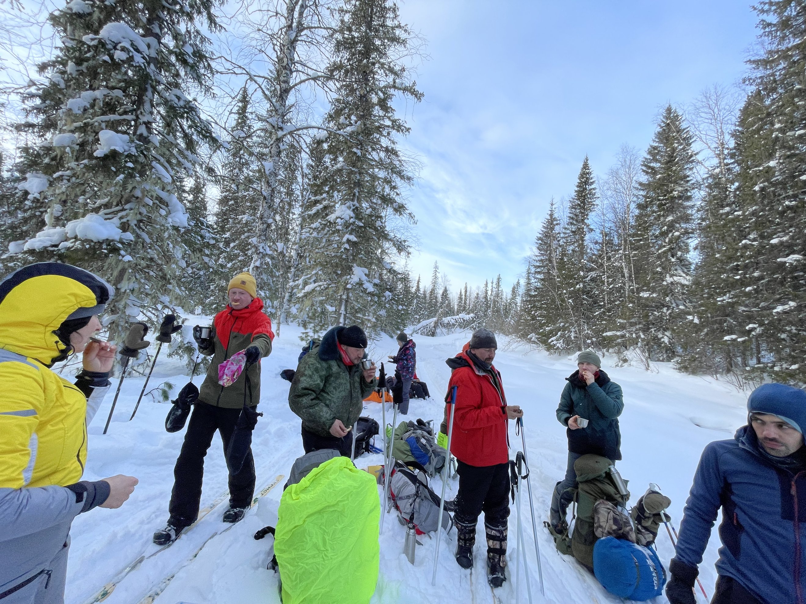 Grupo de pessoas com equipamento de inverno a parar para almoçar na neve