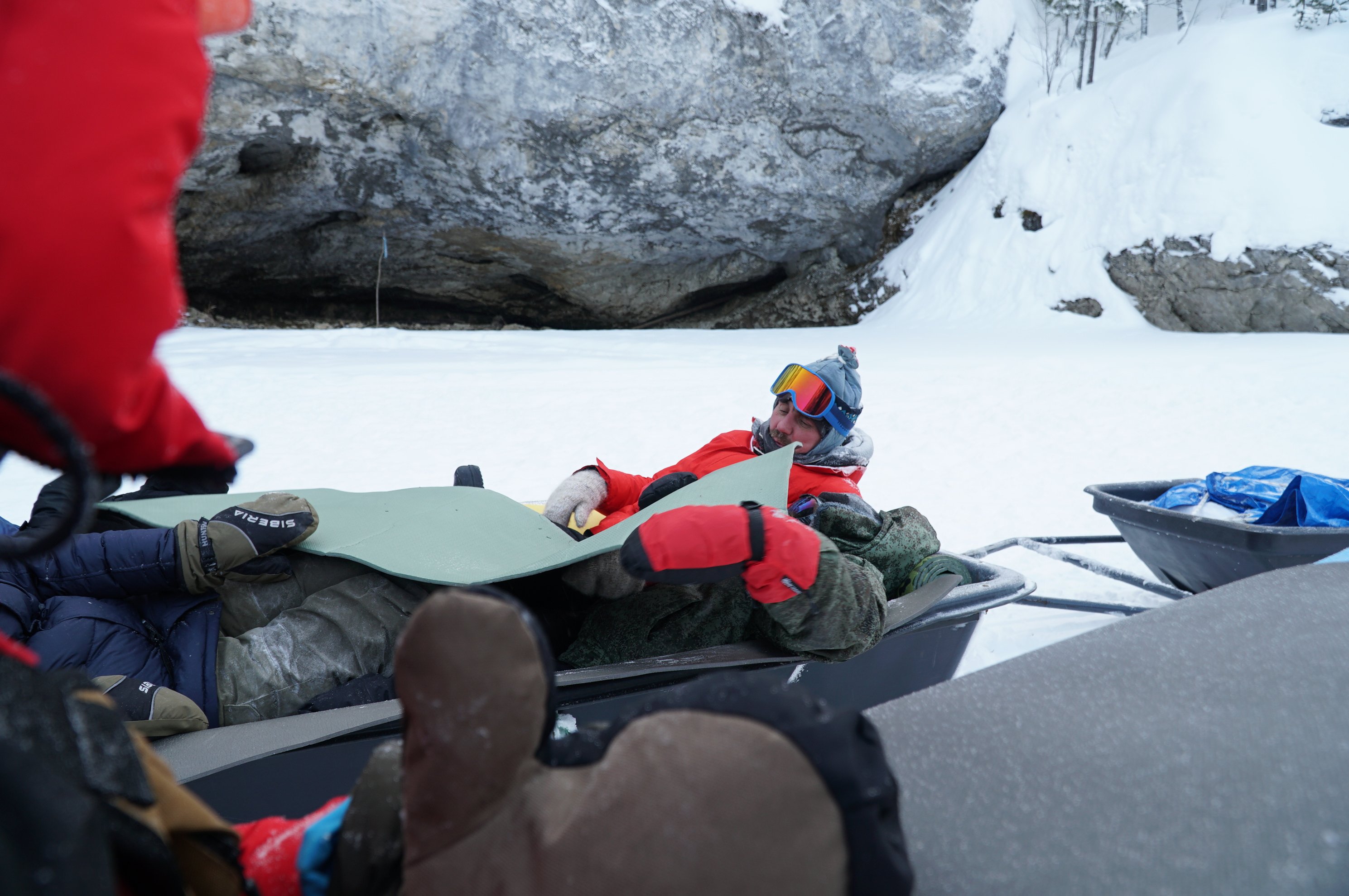 person resting on gear in a snowmobile sled