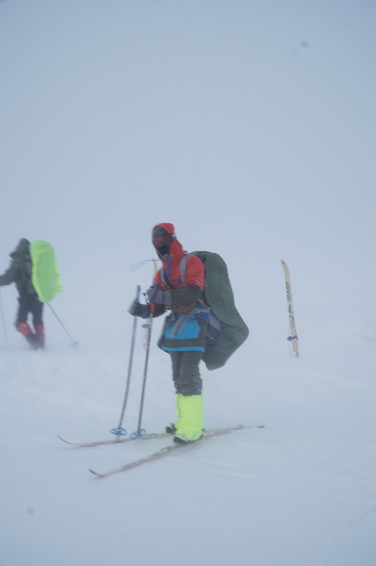 skier with backpack and poles in whiteout conditions