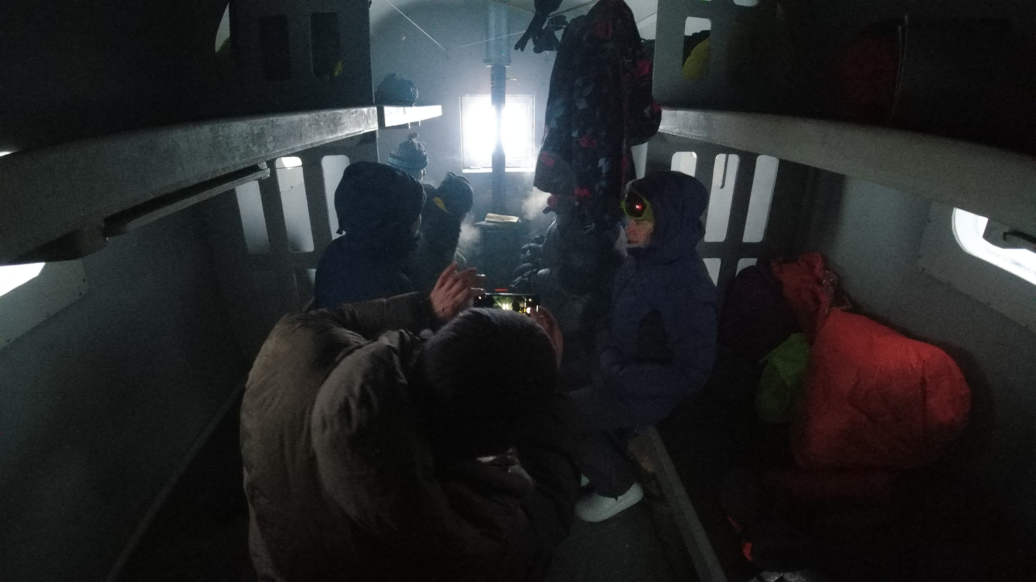 people resting inside a dark mountain refuge