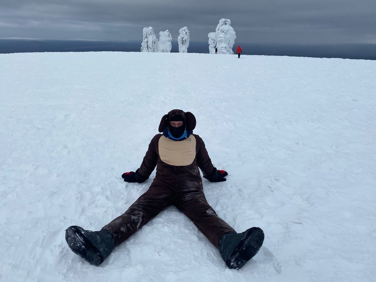 Sergey sitting in snow with stone pillars in the background
