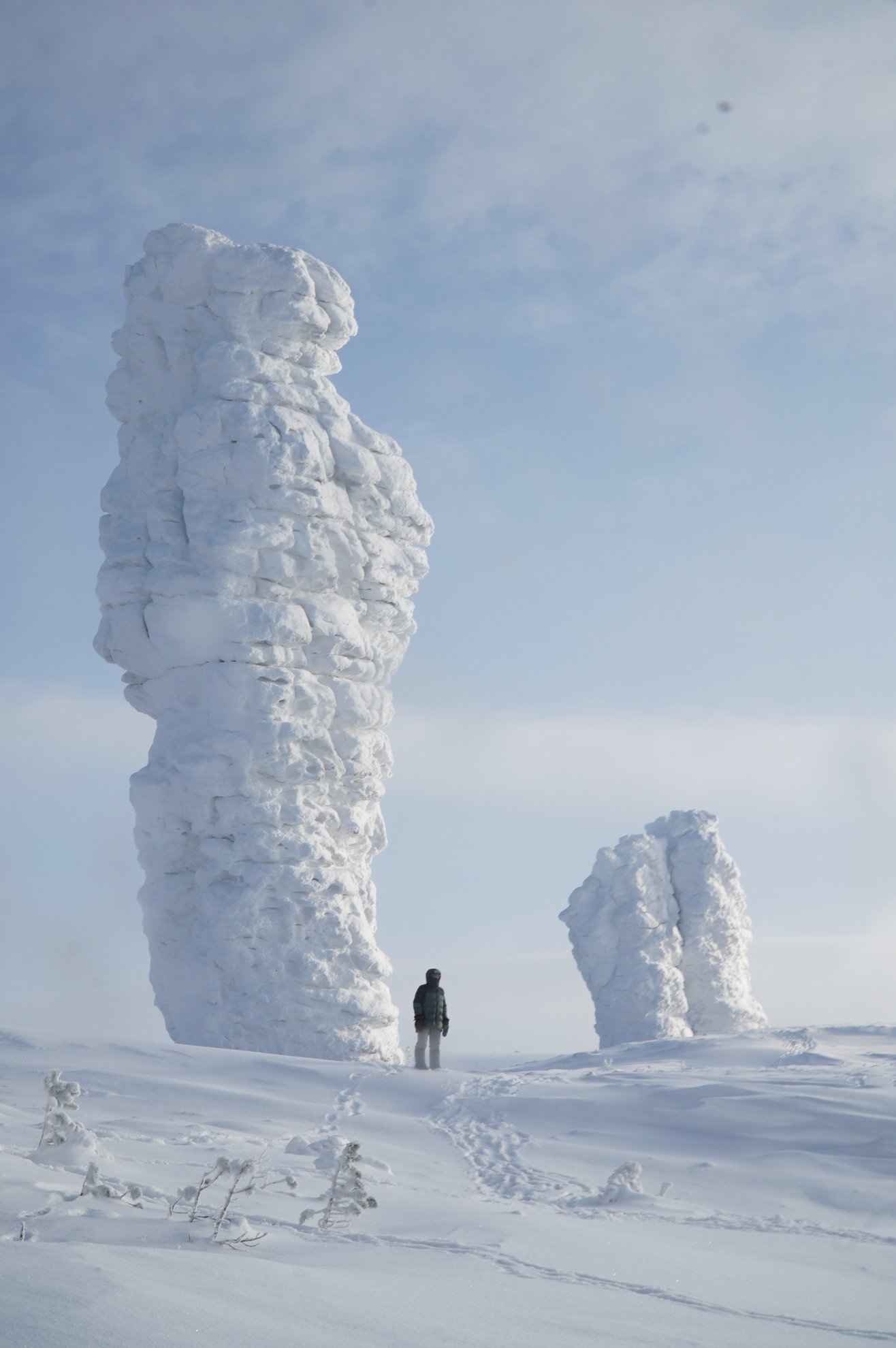 Person standing between snow-covered rock pillars