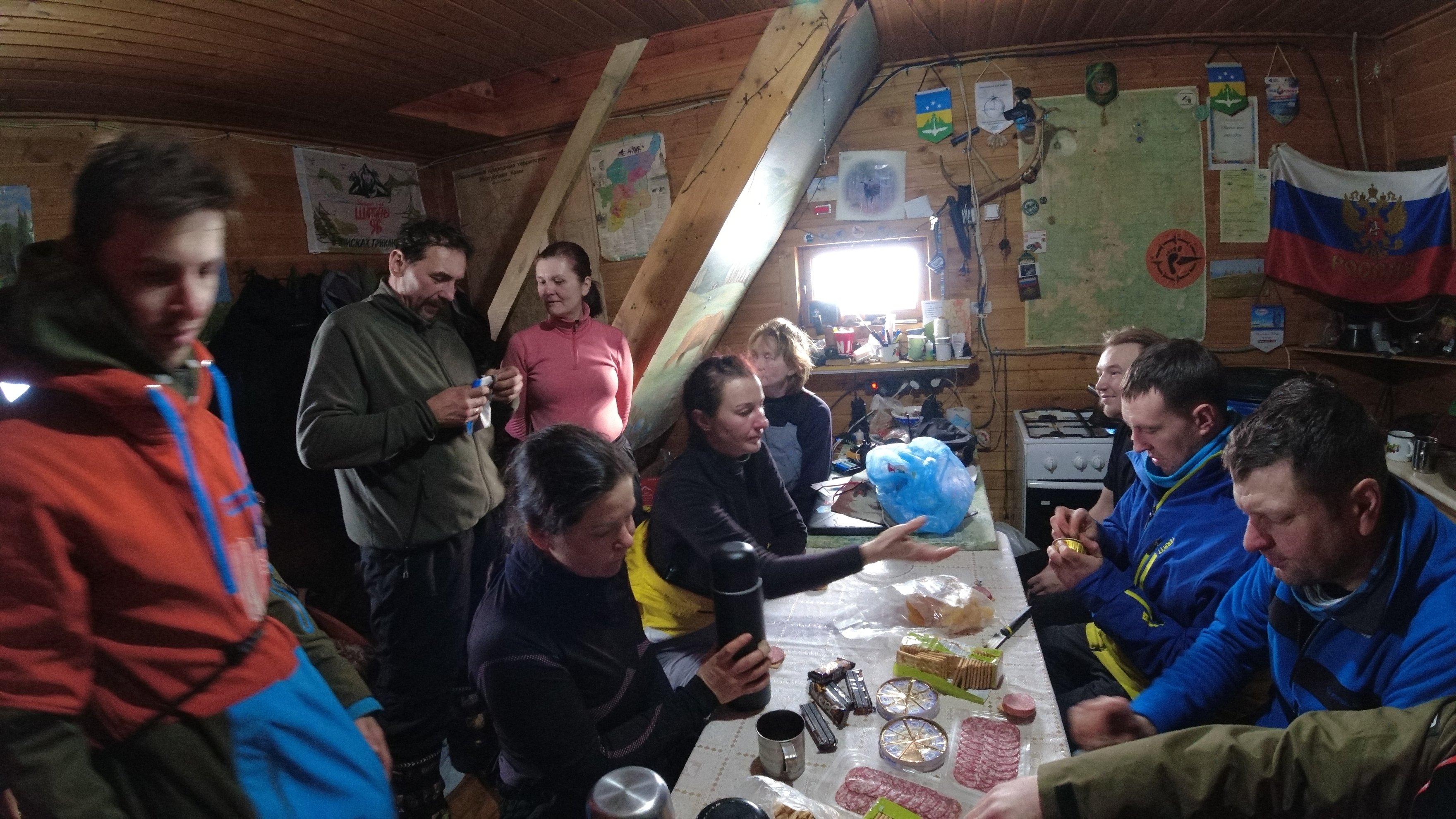 people eating and talking inside a wooden cabin
