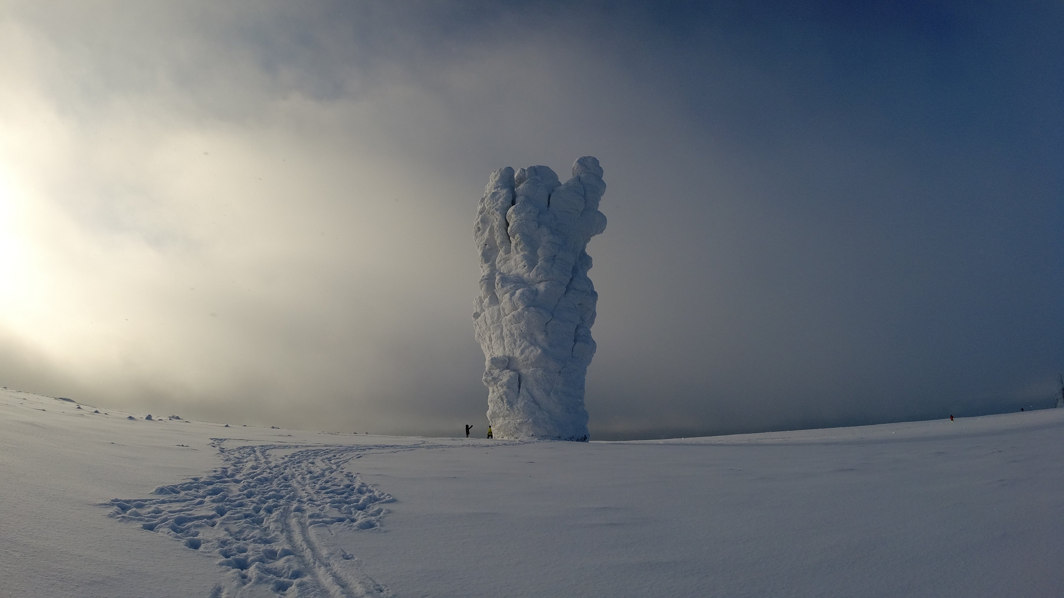 snow-covered rock pillar in a white landscape