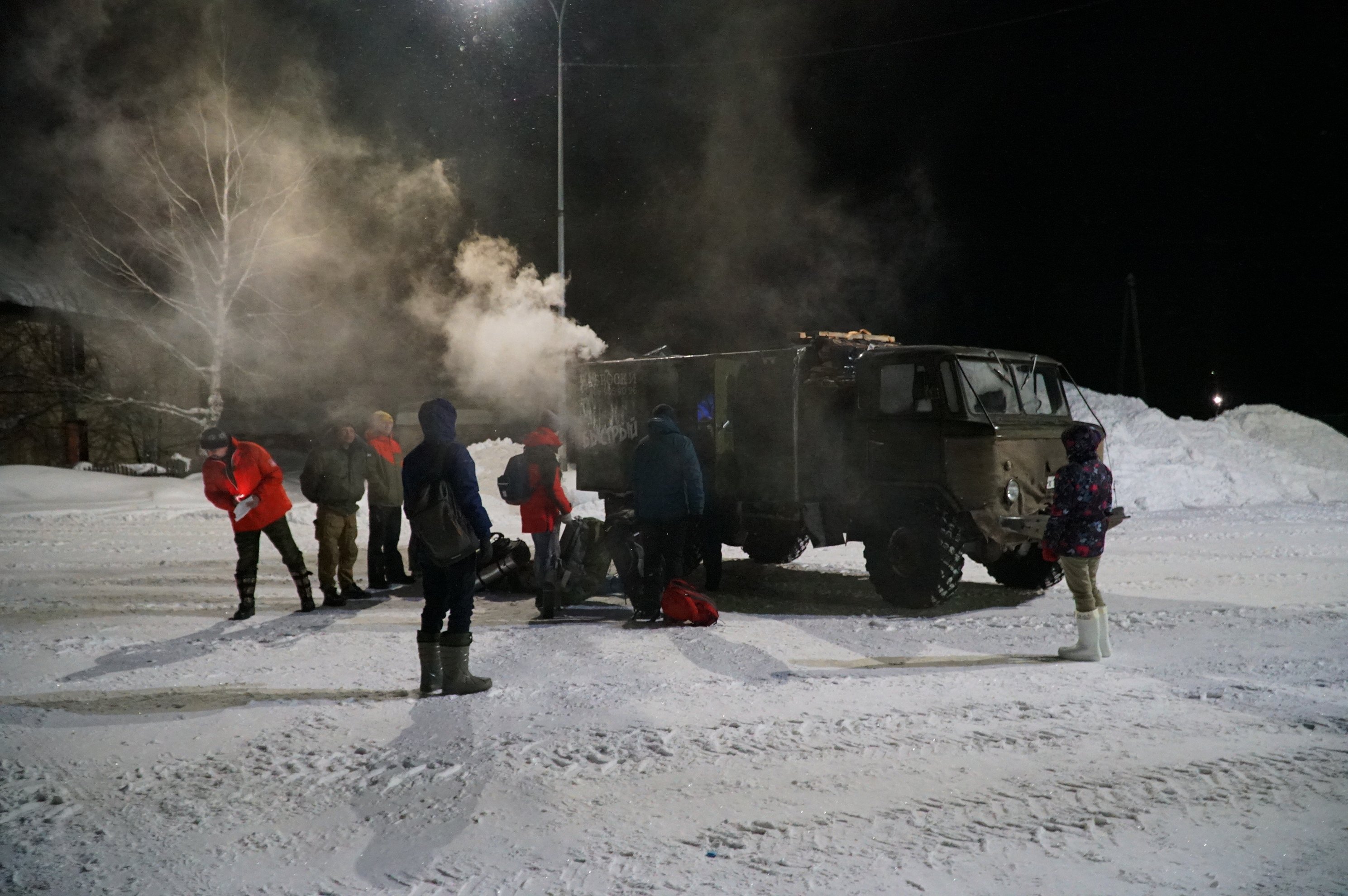 people gathering around a mobile kitchen truck at night