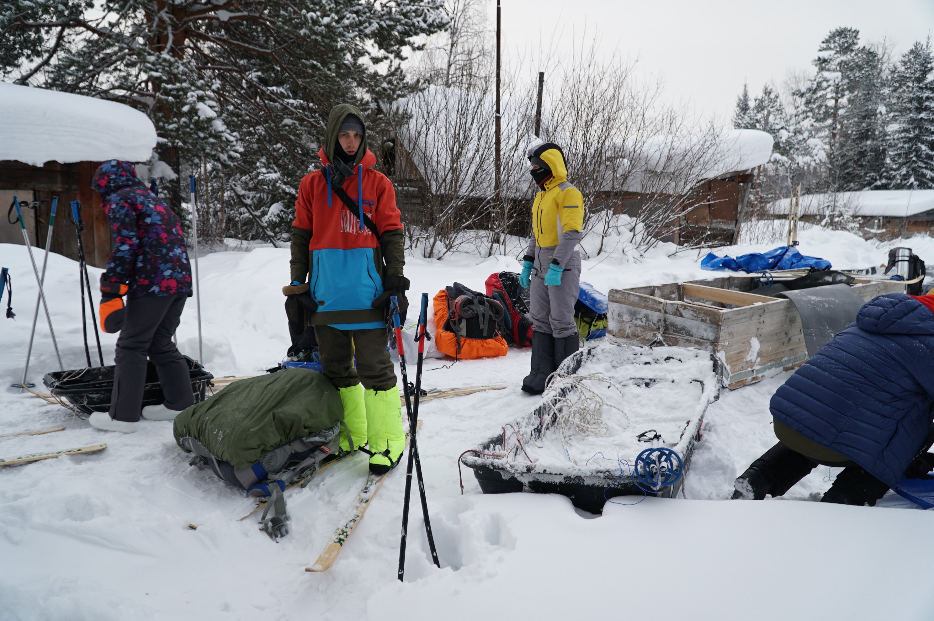 três pessoas com esquis e equipamento na neve