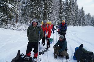 group of skiers with gear standing in snow