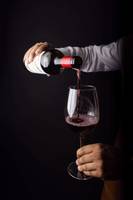 vinho tinto a ser servido de uma garrafa para um copo