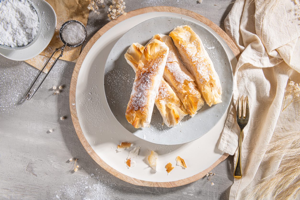 Three pastries on a grey plate with a gold fork