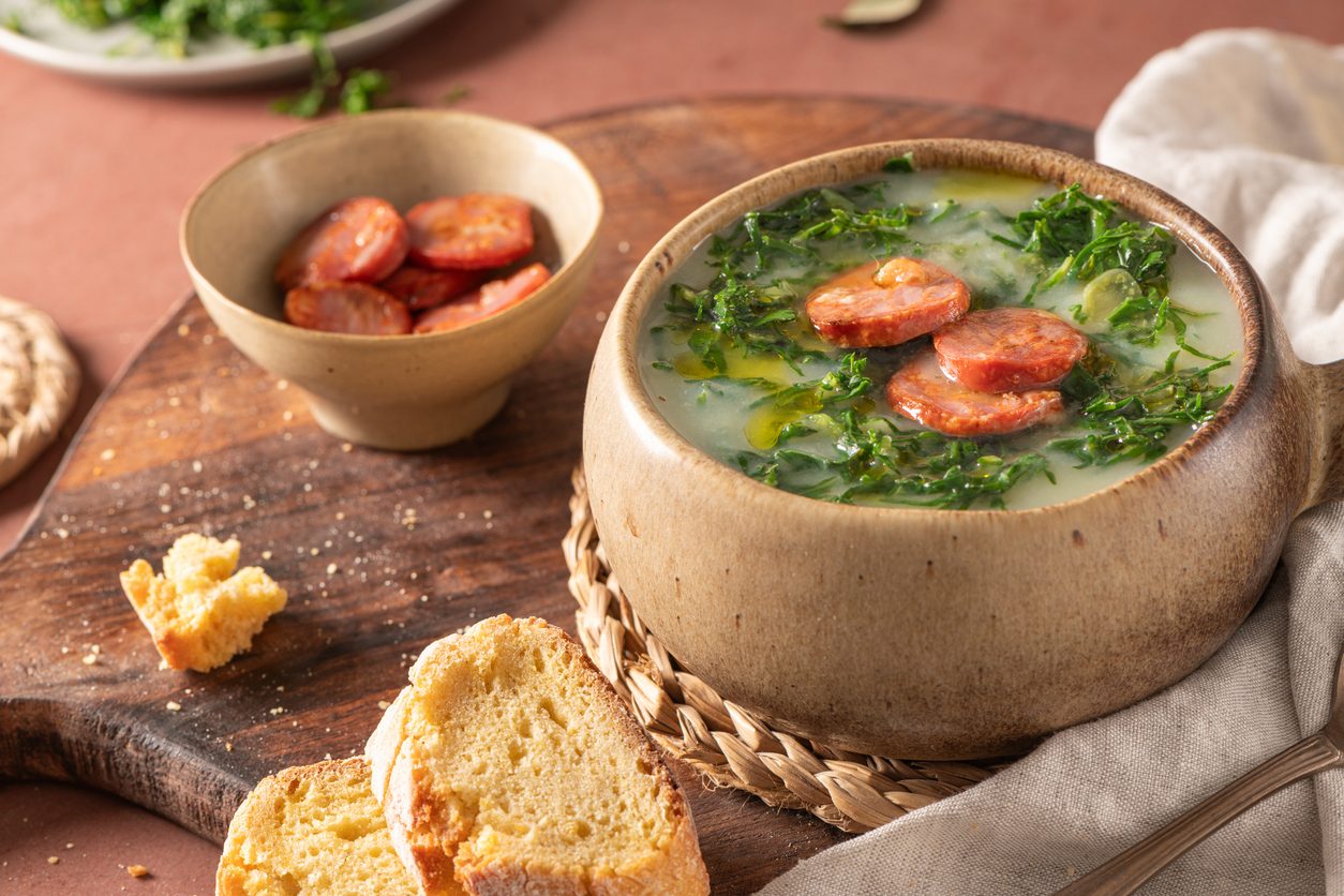 bowl of soup with side of chouriço and broa bread