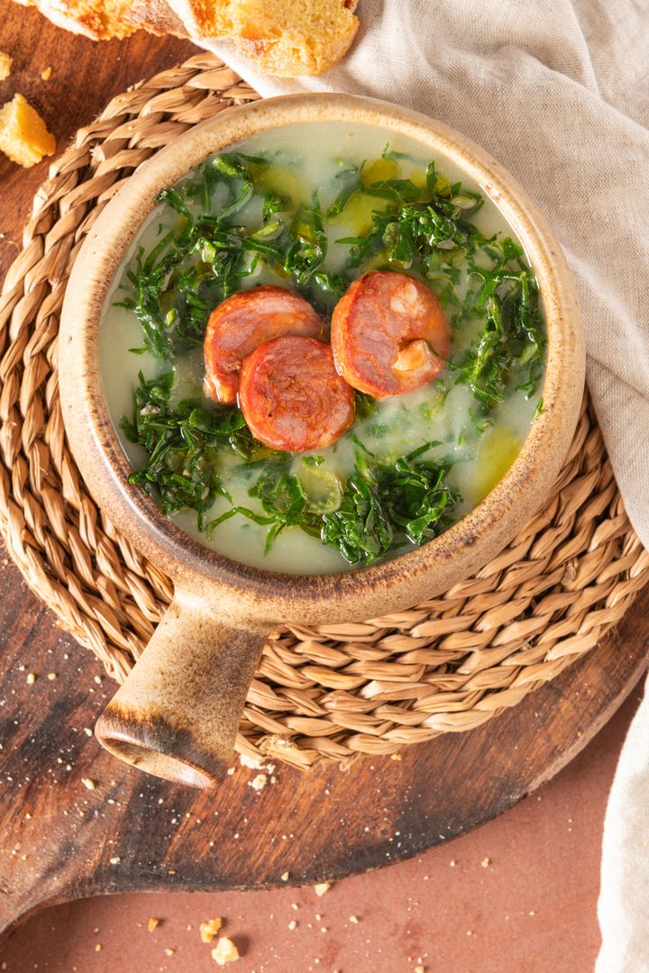 top down view of soup in ceramic bowl on wicker mat