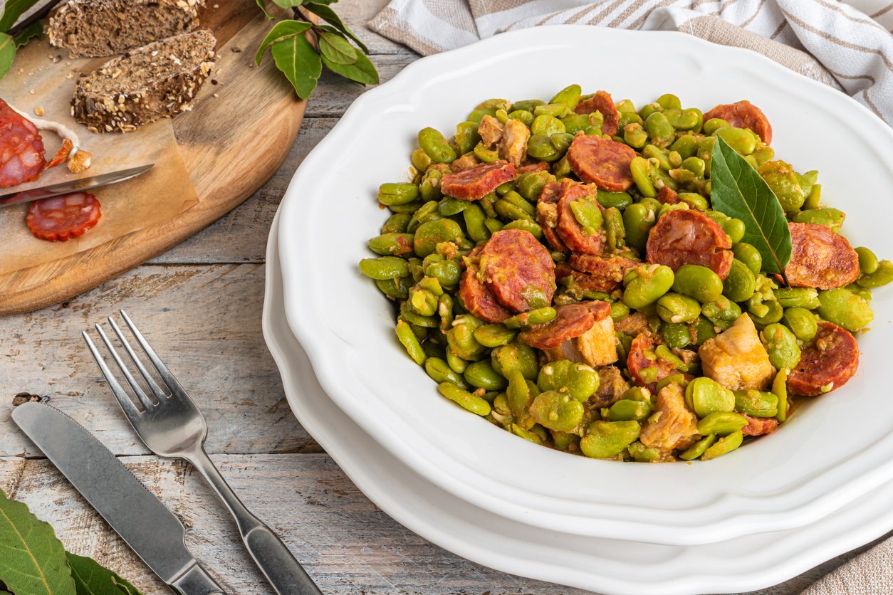 overhead view of plated beans with bread and cutlery