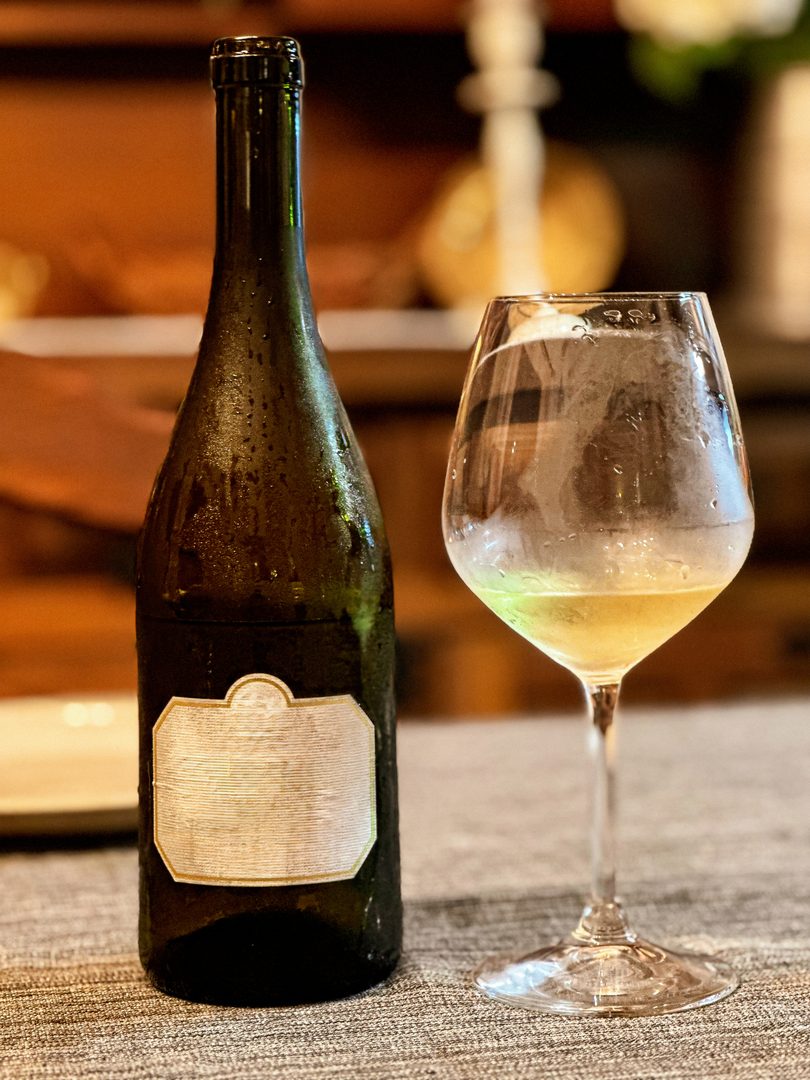garrafa e copo de vinho sobre uma superfície texturada