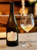 garrafa e copo de vinho sobre uma superfície texturada