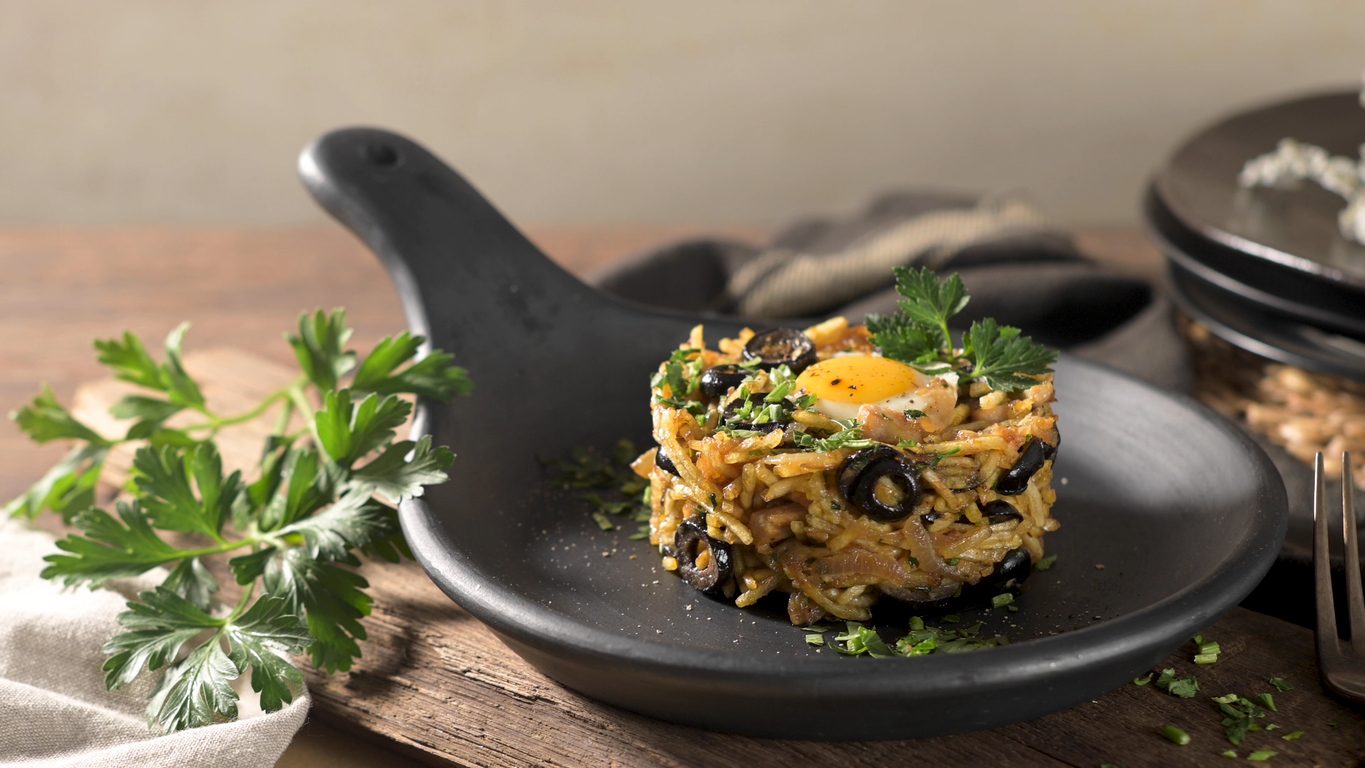 Close-up of the dish plated in a black ceramic pan