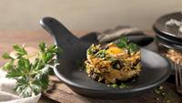 Close-up of the dish plated in a black ceramic pan