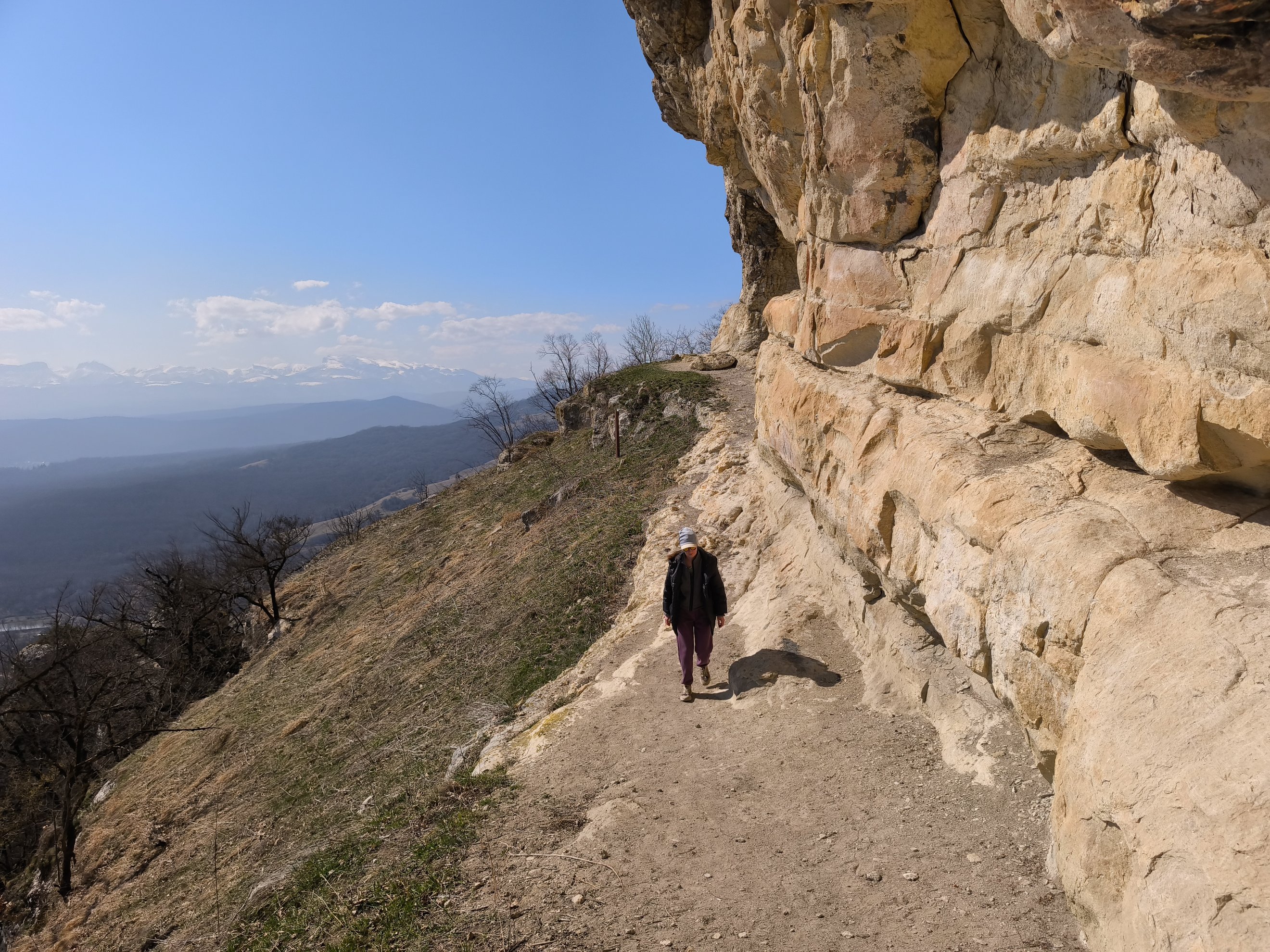 dirt path running alongside a high rock wall