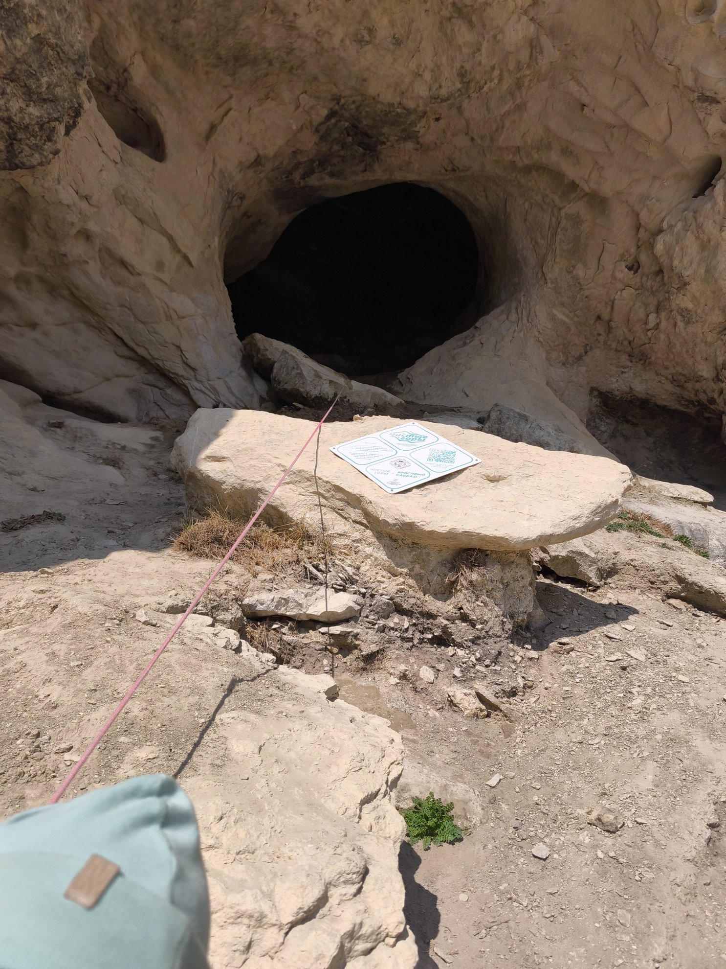 entrance to a cave with a map on a rock