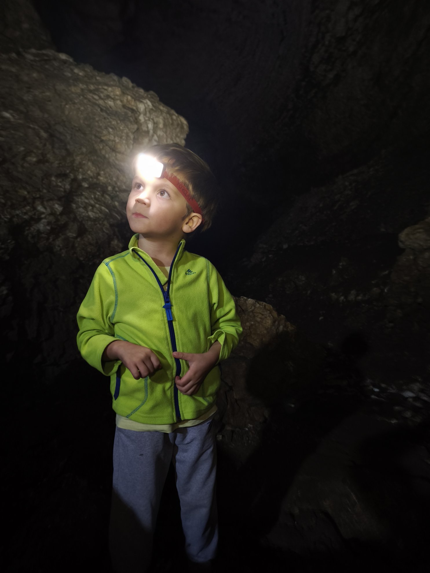 person wearing a headlamp inside the cave