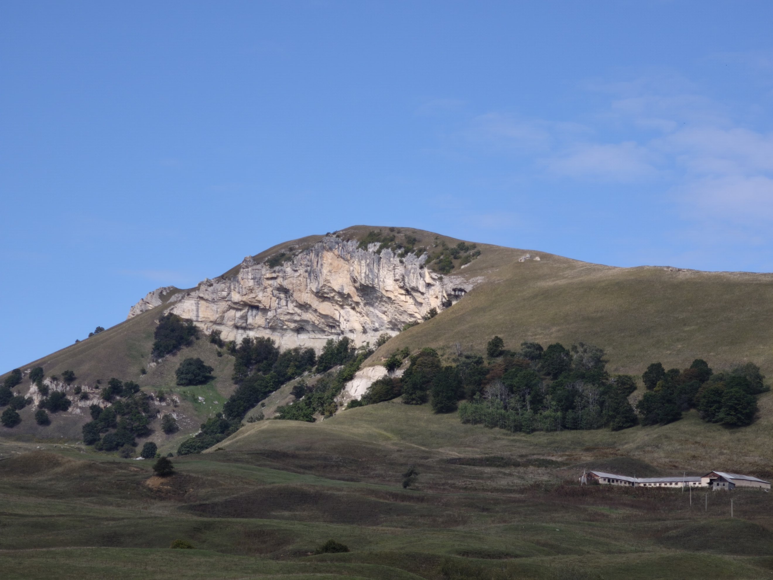 wide shot of the rock face and surrounding slopes