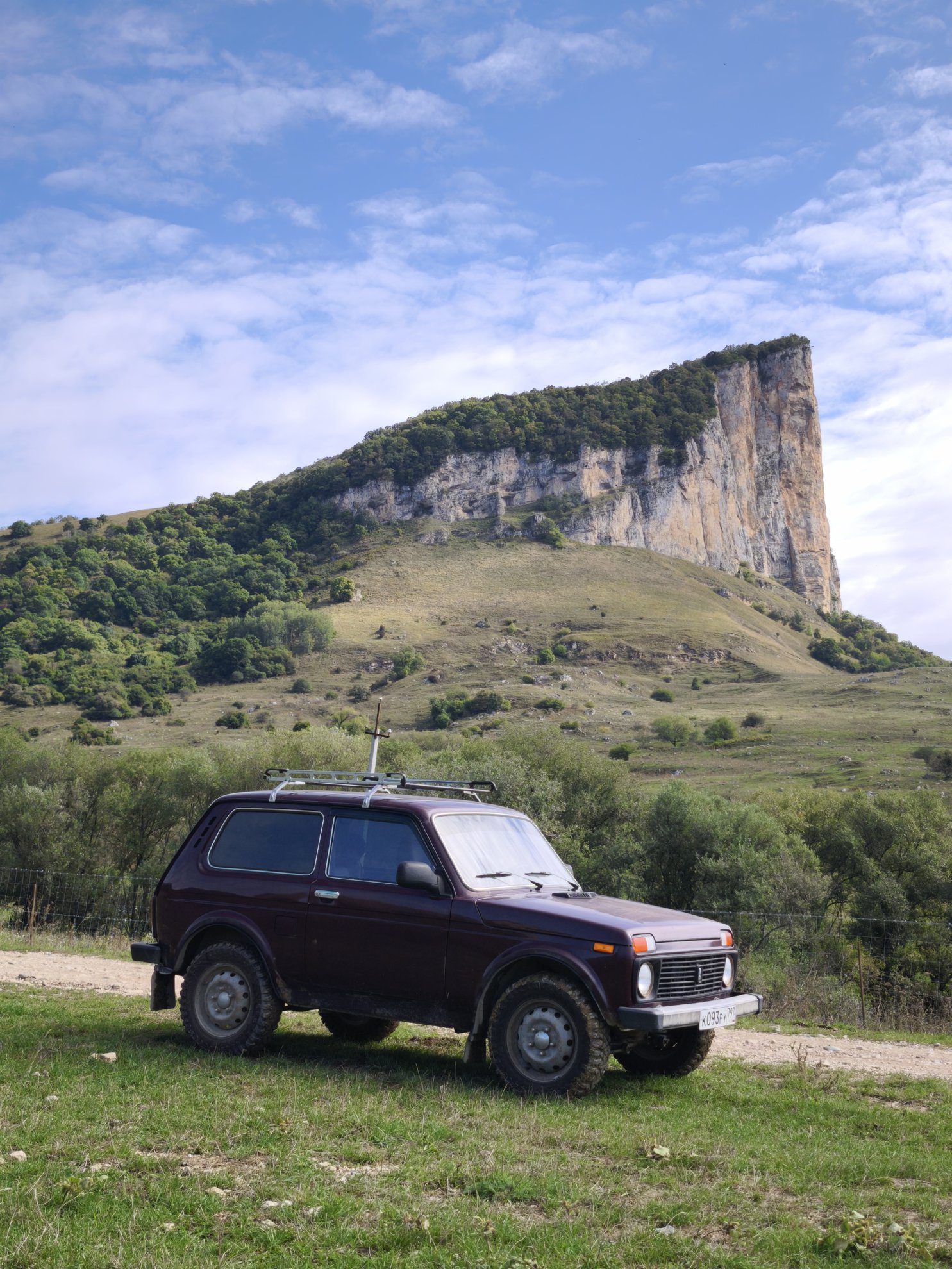 off road vehicle parked in front of the cliff