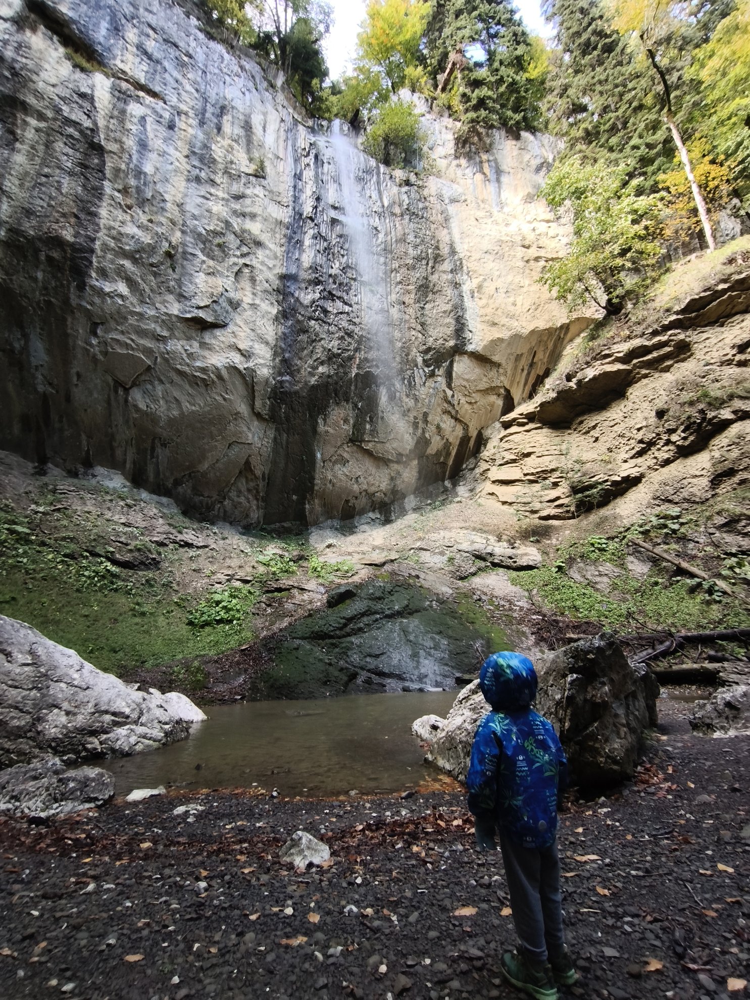 View of the waterfall falling against a rock wall