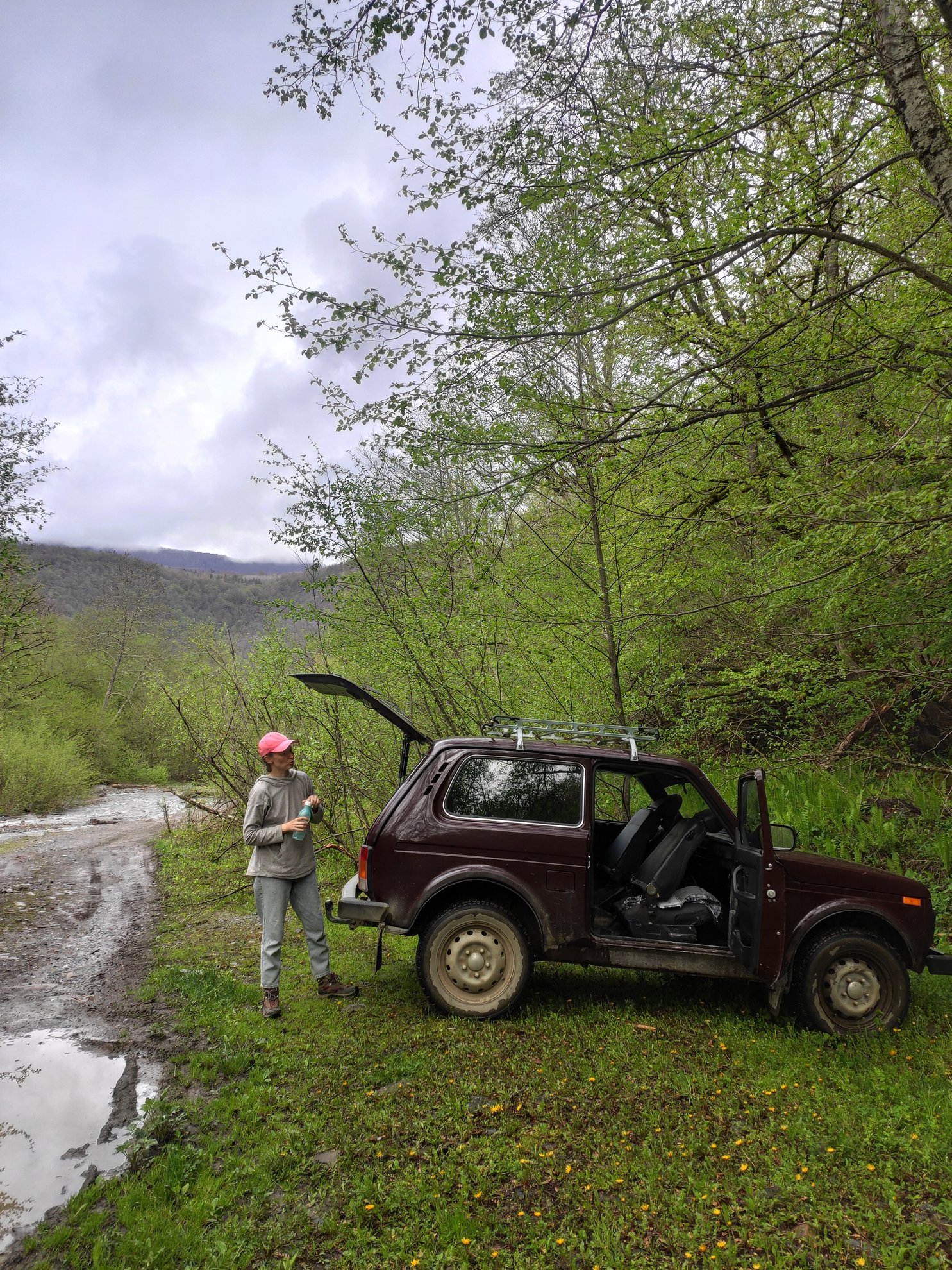 off-road vehicle parked on a dirt path by the woods